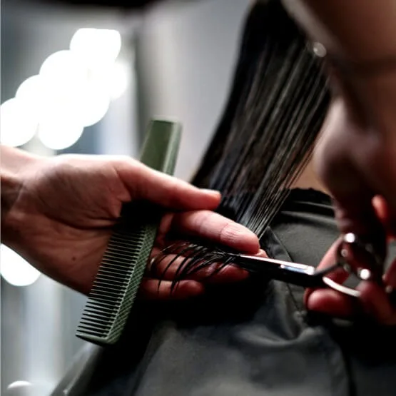 Detailaufnahme eines Haarschnitts mit Schere und Kamm